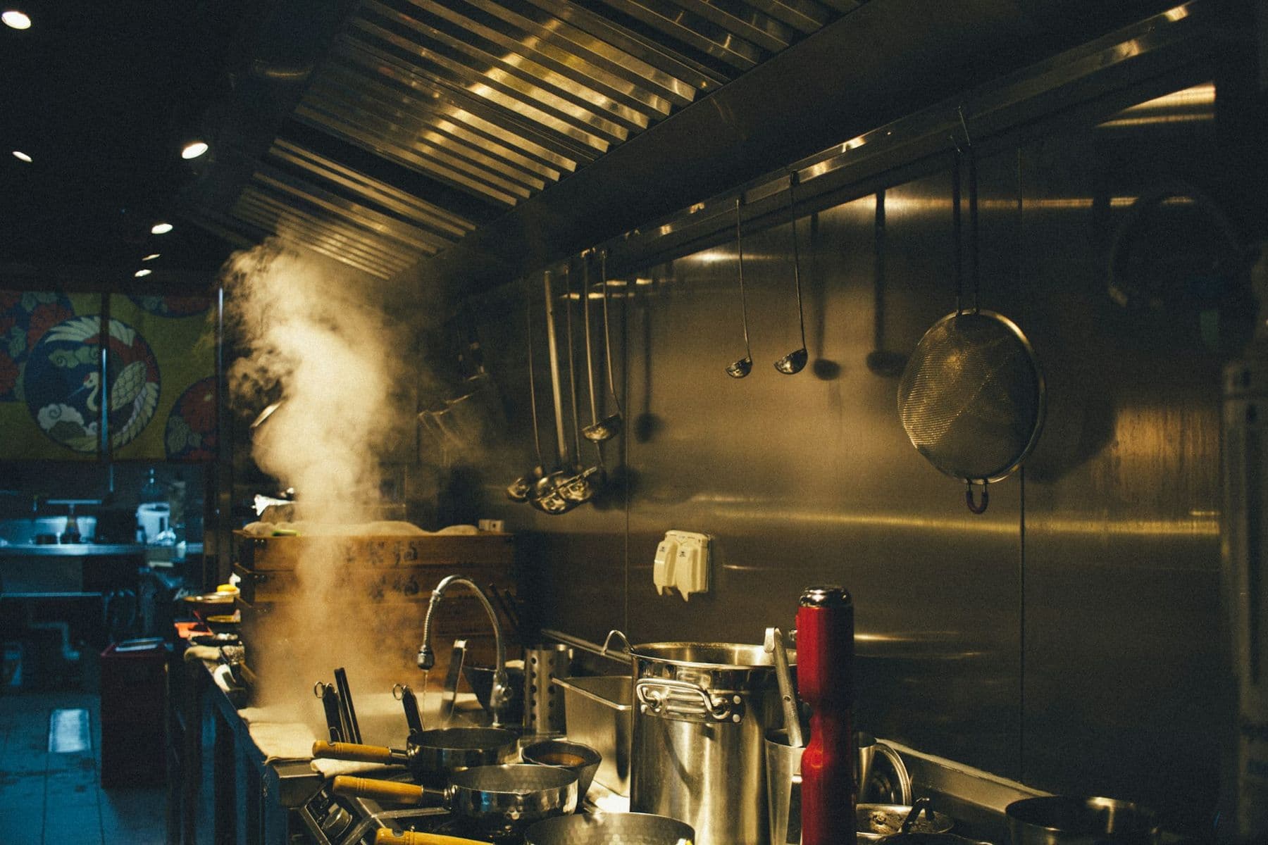 Steam rising off the stock pots on a restaurant cook line